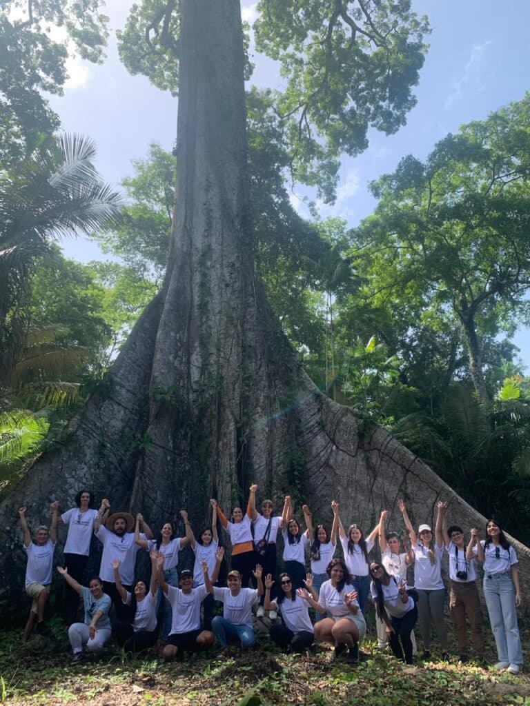 Grupo de pessoas em frente a uma árvore grande